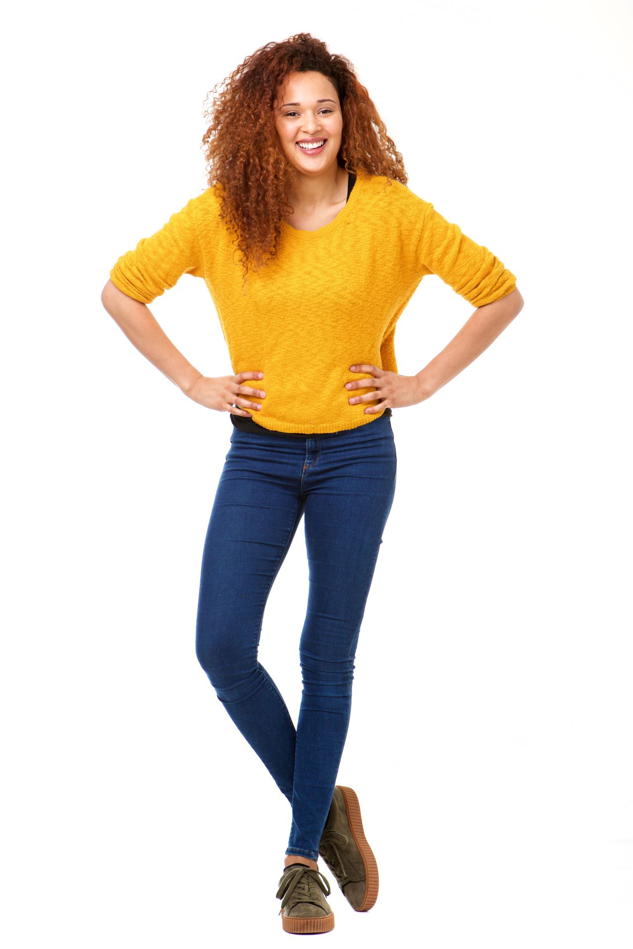Femme confiante et souriante, les mains sur les hanches.